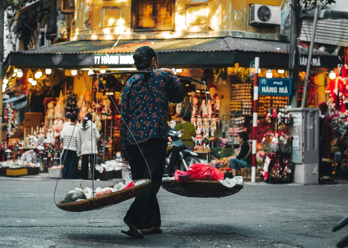 https://api-staging.holicay.com/uploads/large_1e872ff1-webp-a-woman-carrying-winnowing-baskets-with-fresh-fruits.webp